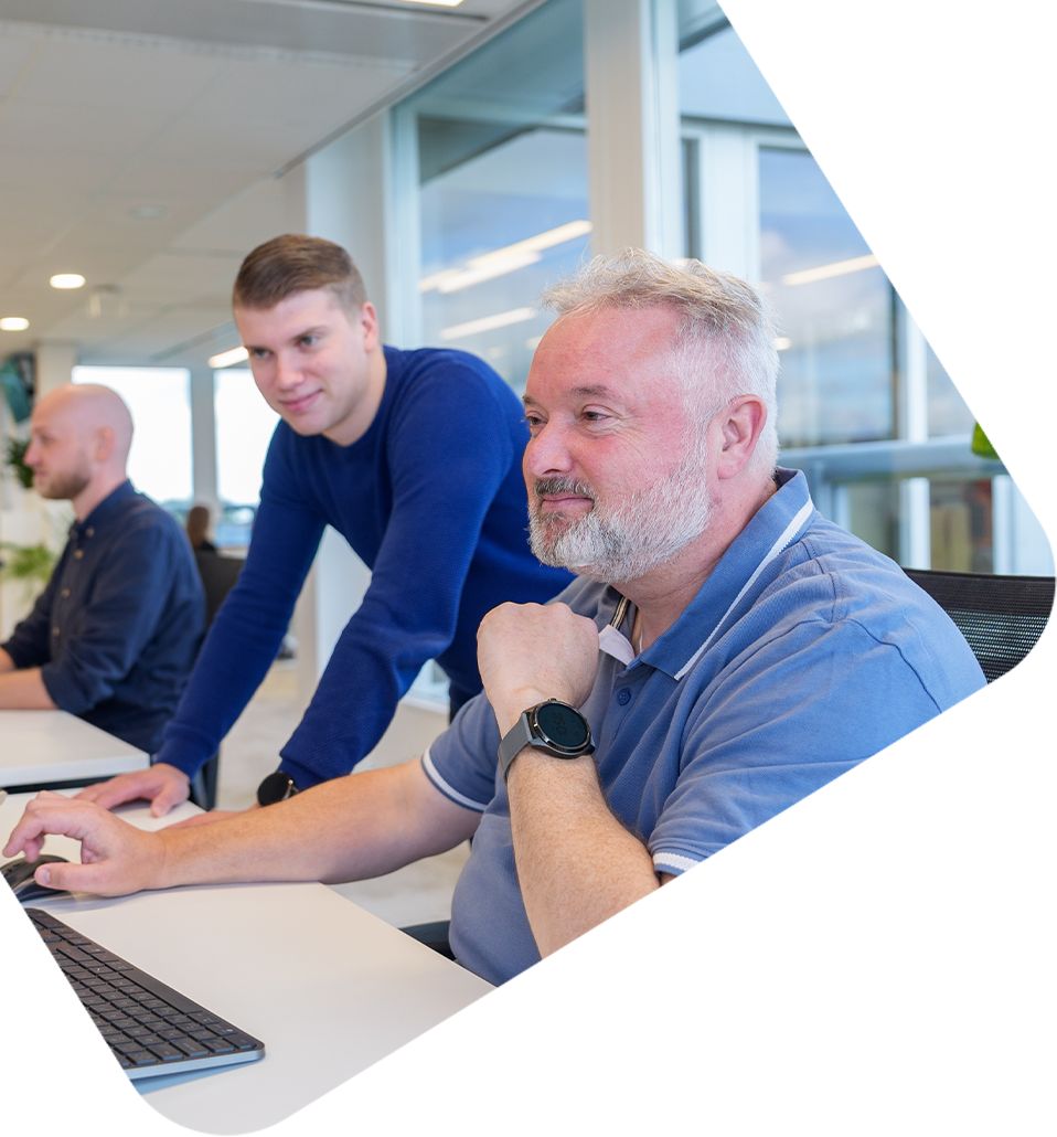 Twee collega’s achter een laptop in een modern kantoor, gericht op webshopdata en conversie-optimalisatie.